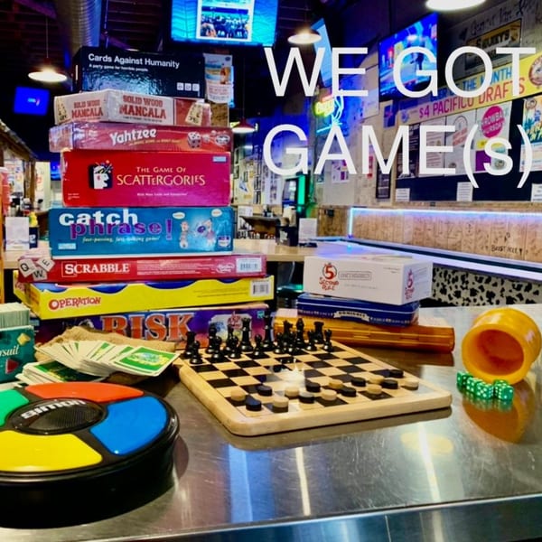 A stack of board games and card games on a table at Swanky's Vittles and Libations.