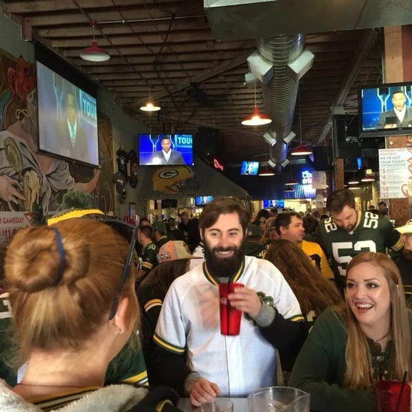 Patrons in sports jerseys watching TV screens at Swanky's Vittles and Libations bar-&-grill.